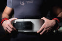 A person wearing a thick white powerlifting belt with a black adjustable lever buckle around their waist.